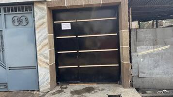 A gated entrance with a metal door and a small sign.