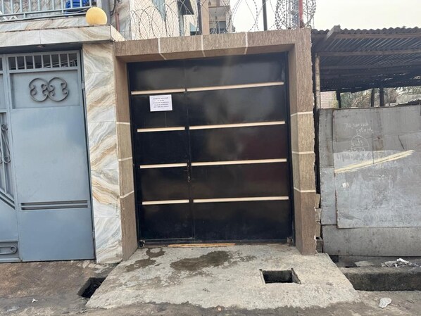 A gated entrance with a metal door and a small sign. - Cozy home with Wi-Fi and air conditioning (Kinshasa)