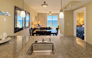 A hotel room with a dining area, a large window with a view, a sink, and a ceiling fan. - Family Friendly Gulf View Free Beach Chairs (Mar. 2027) & Activities Daily! (Panama City Beach)