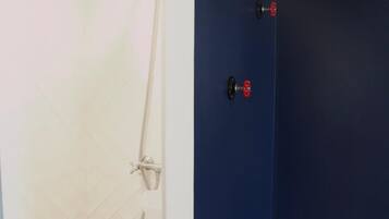 Ein Badezimmer mit Dusche, Waschbecken und einer dunkelblauen Wand.