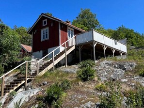 Un edificio rojo con una escalera de madera que conduce a una estructura blanca superior.