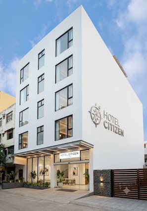 Ein modernes Hotelgebäude mit einem gut sichtbaren Schild, auf dem 'HOTEL CITIZEN' steht.