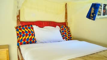 A bed with a canopy, a wooden headboard, and colorful pillows.