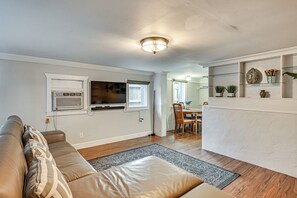 A modern living room with a leather sofa, a flat-screen TV, and a dining area with a table and chairs. - 3 Mi to Dtwn! Cozy Tampa Home Base (Tampa)