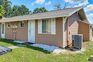 A single-story mobile home with a front door, two windows, and an attached air conditioning unit. - Coconut Cottage: Community Amenities, Near Disney (Clermont)