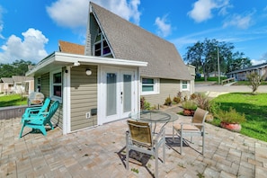 A house with a covered patio, a barbecue grill, and outdoor seating. - Sun-kissed Cottage: Lake Access, 14 Mi to Disney (Clermont)