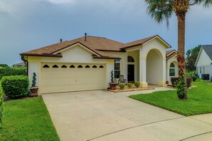 A single-story house with a garage, a covered porch, and a well-maintained lawn. - Spacious 4BR w/ South-facing Pool/spa: Disney 11mi (Clermont)