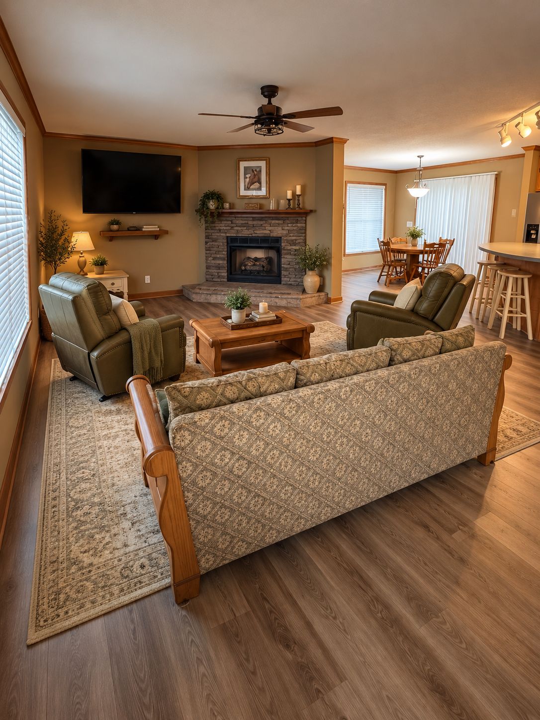 A living room with a fireplace, leather sofas, a coffee table, and a television mounted on the wall.