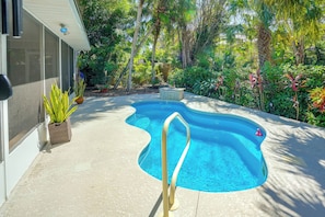 A swimming pool with a wavy edge, surrounded by a variety of plants and trees. - 4 Minute Walk to Private Beach Plus a Private Pool (Vero Beach)
