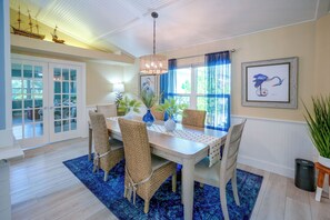 A dining area with a table, chairs, and a blue rug. - 4 Minute Walk to Private Beach Plus a Private Pool (Vero Beach)