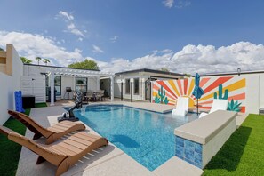 Piscina com espreguiçadeiras e área de terraço.