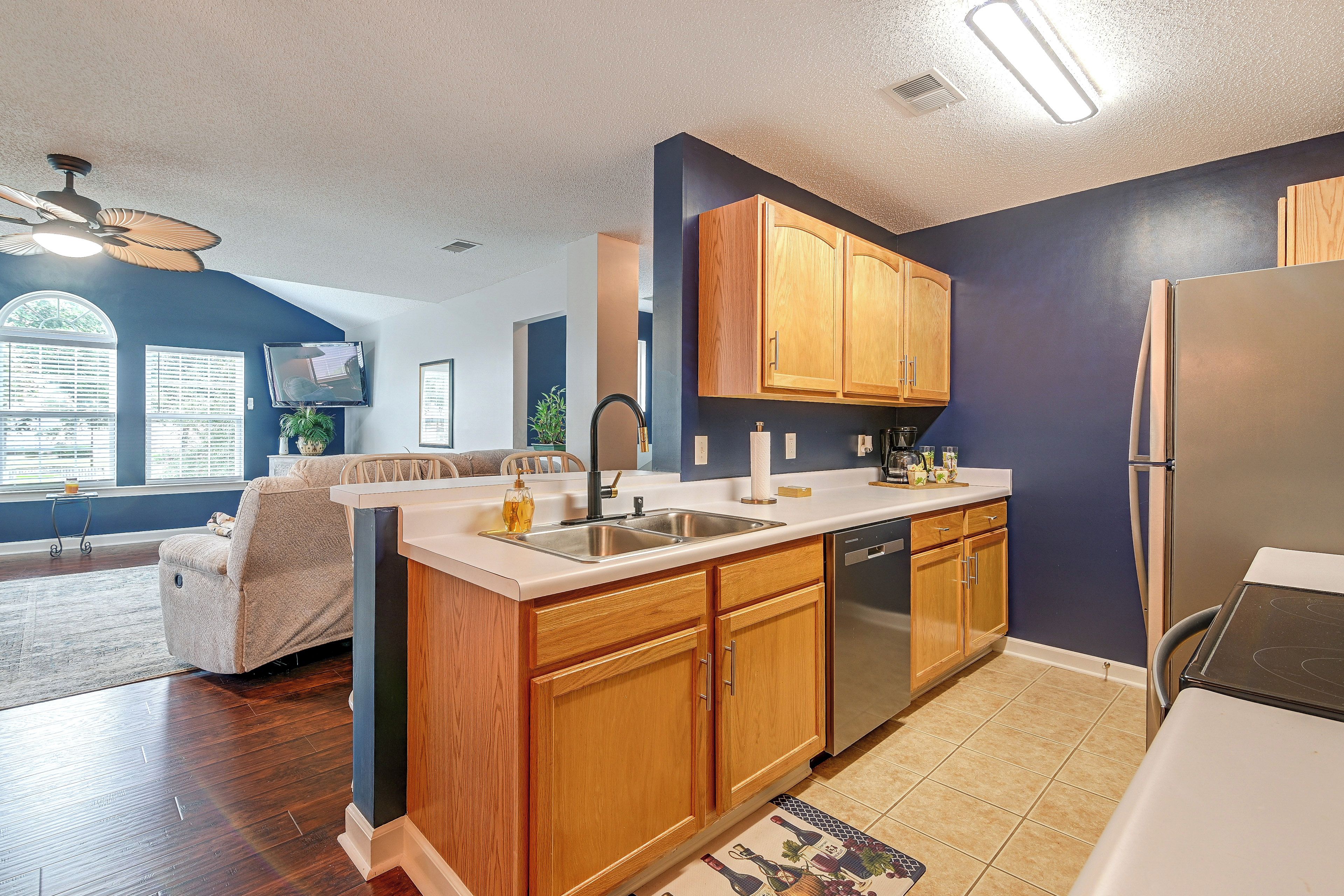 A modern kitchen with wooden cabinets, a stainless steel sink, and a built-in dishwasher.