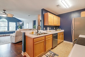 A modern kitchen with wooden cabinets, a stainless steel sink, and a built-in dishwasher. - Murrells Inlet Condo: Close to Beaches, Amenities (Murrells Inlet)