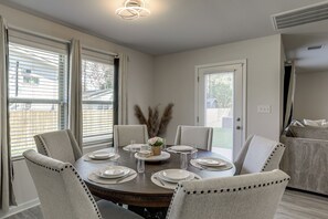 A dining room with a round table set for six, surrounded by six chairs. - The Geaux House - 1 Mi to Tiger Stadium (Baton Rouge)