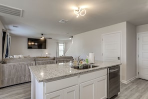 A modern kitchen with a granite countertop, stainless steel appliances, and a built-in dishwasher. - The Geaux House - 1 Mi to Tiger Stadium (Baton Rouge)