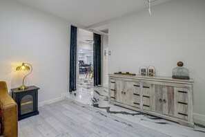 A hallway with a marble floor, a dark-toned cabinet with handles, and a lamp on a side table. - Near Shopping & Dining! Family Escape in Mcallen (McAllen)