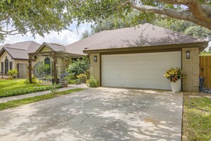 A residential driveway leading to a garage with a brick facade and a sloped roof. - Near Shopping & Dining! Family Escape in Mcallen (McAllen)