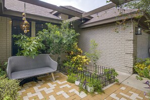A courtyard with a bench, potted plants, a black fence, and a brick wall. - Near Shopping & Dining! Family Escape in Mcallen (McAllen)