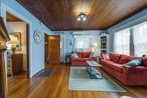 A cozy living room with a wooden ceiling, a red sofa set, a coffee table, and a large wall clock. - Steps to Shore! Old Orchard Beach Gem w/ Patio (Old Orchard Beach)