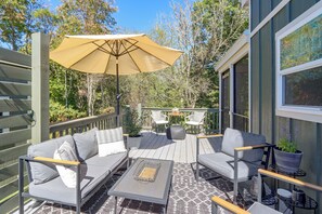 Eine Terrasse im Freien mit einer Sofagarnitur, einem Tisch und einem Sonnenschirm.