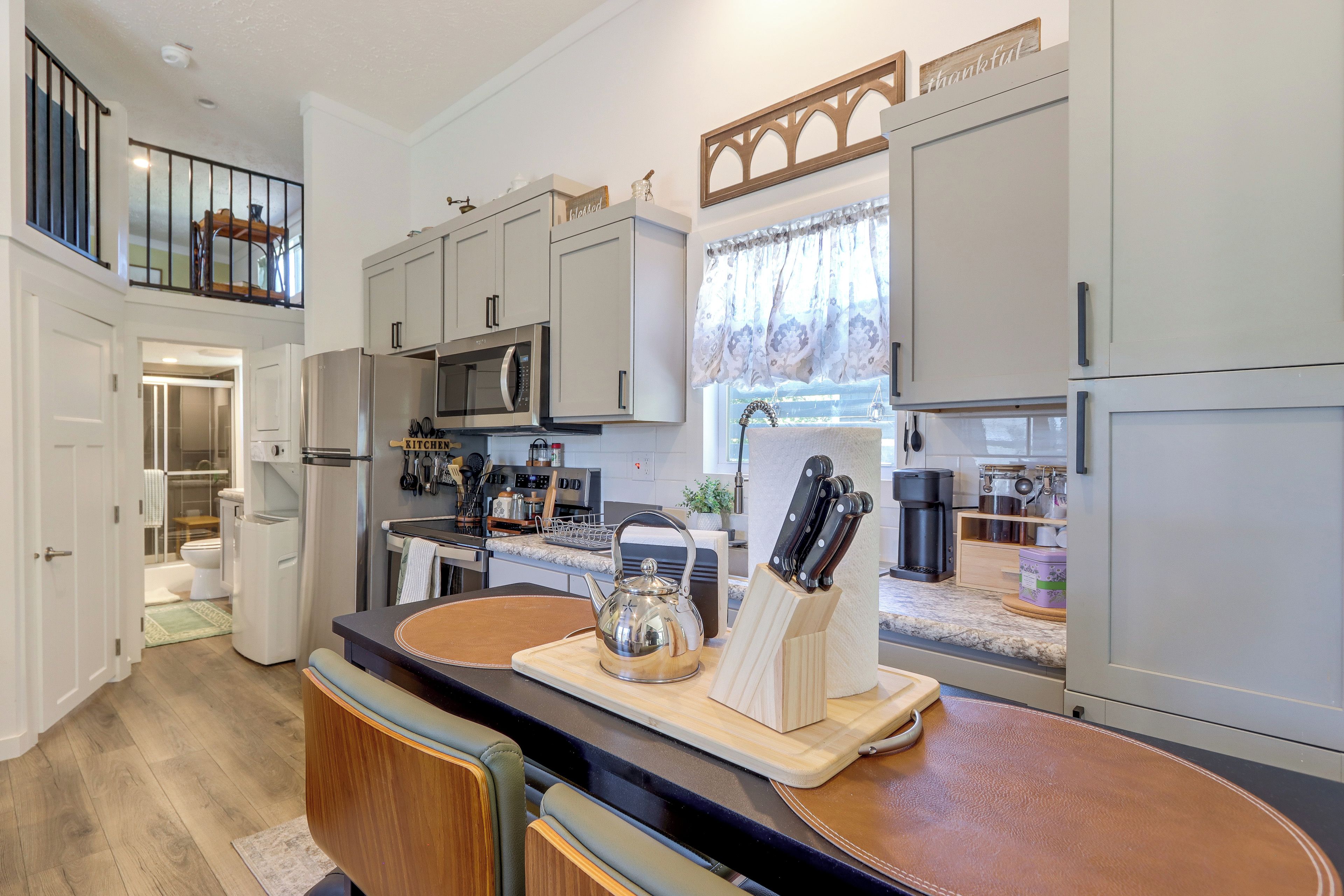 A modern kitchen with a central island, stainless steel appliances, and a view to the outdoors.