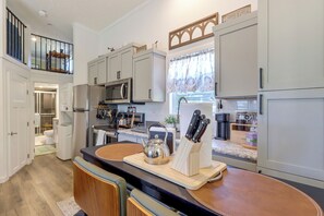 A modern kitchen with a central island, stainless steel appliances, and a view to the outdoors. - Screened Porch w/ Fireplace! copperhill Tiny Home (Copperhill)