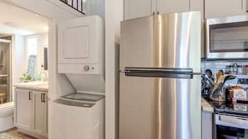 Una cocina con un refrigerador de acero inoxidable, un horno empotrado y un microondas.