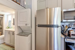 A kitchen with a stainless steel refrigerator, a built-in oven, and a microwave. - Screened Porch w/ Fireplace! copperhill Tiny Home (Copperhill)