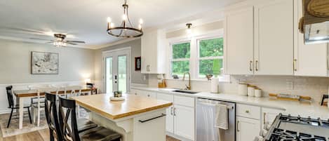A modern kitchen with white cabinetry, a central island, and a gas stove.