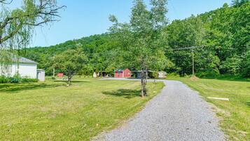A gravel path leading to a red building surrounded by greenery and trees.