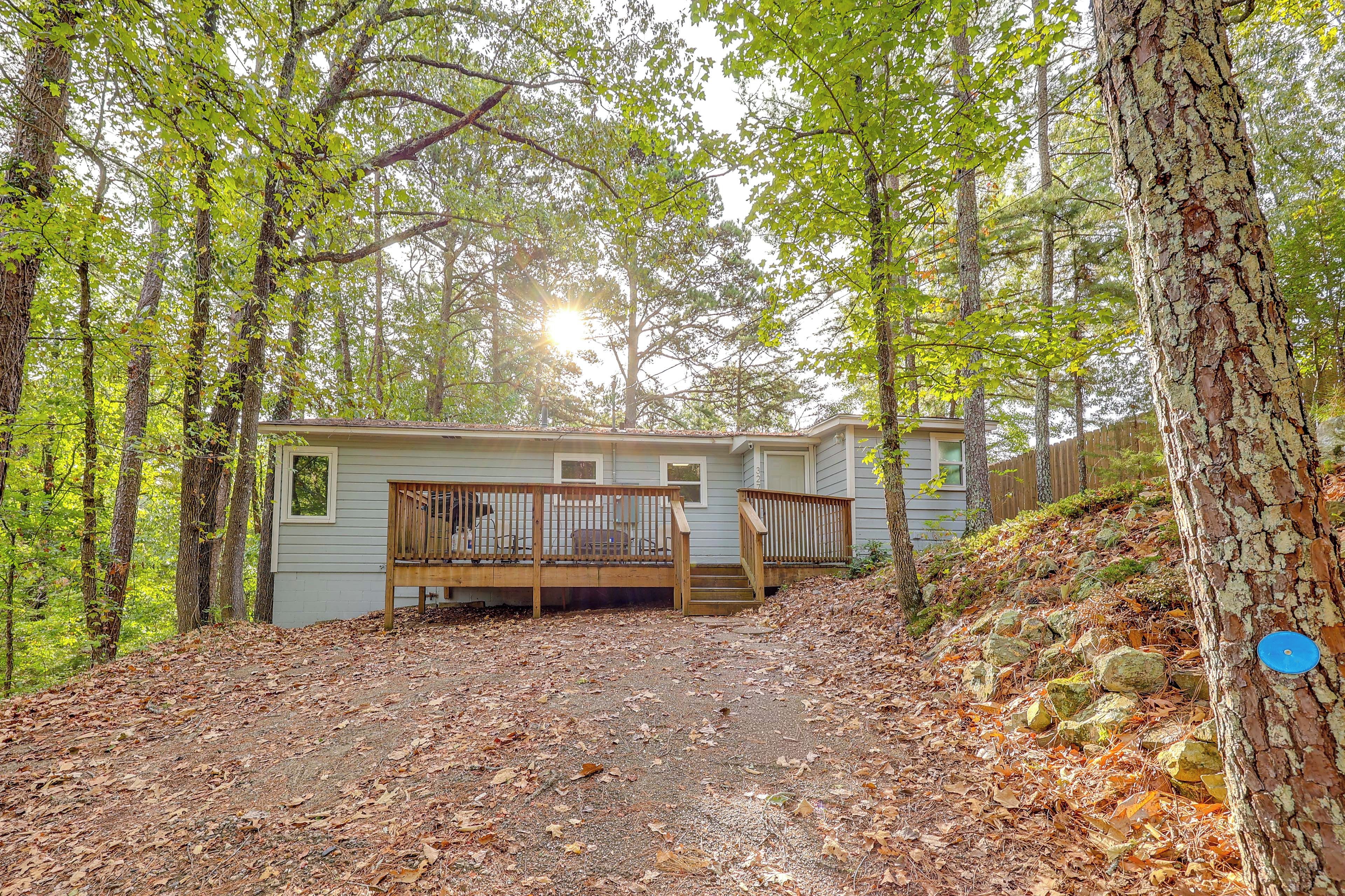 Une cabane dotée d’une terrasse en bois et d’un chemin en pierre menant à l’entrée.