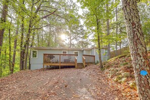Une cabane dotée d’une terrasse en bois et d’un chemin en pierre menant à l’entrée.