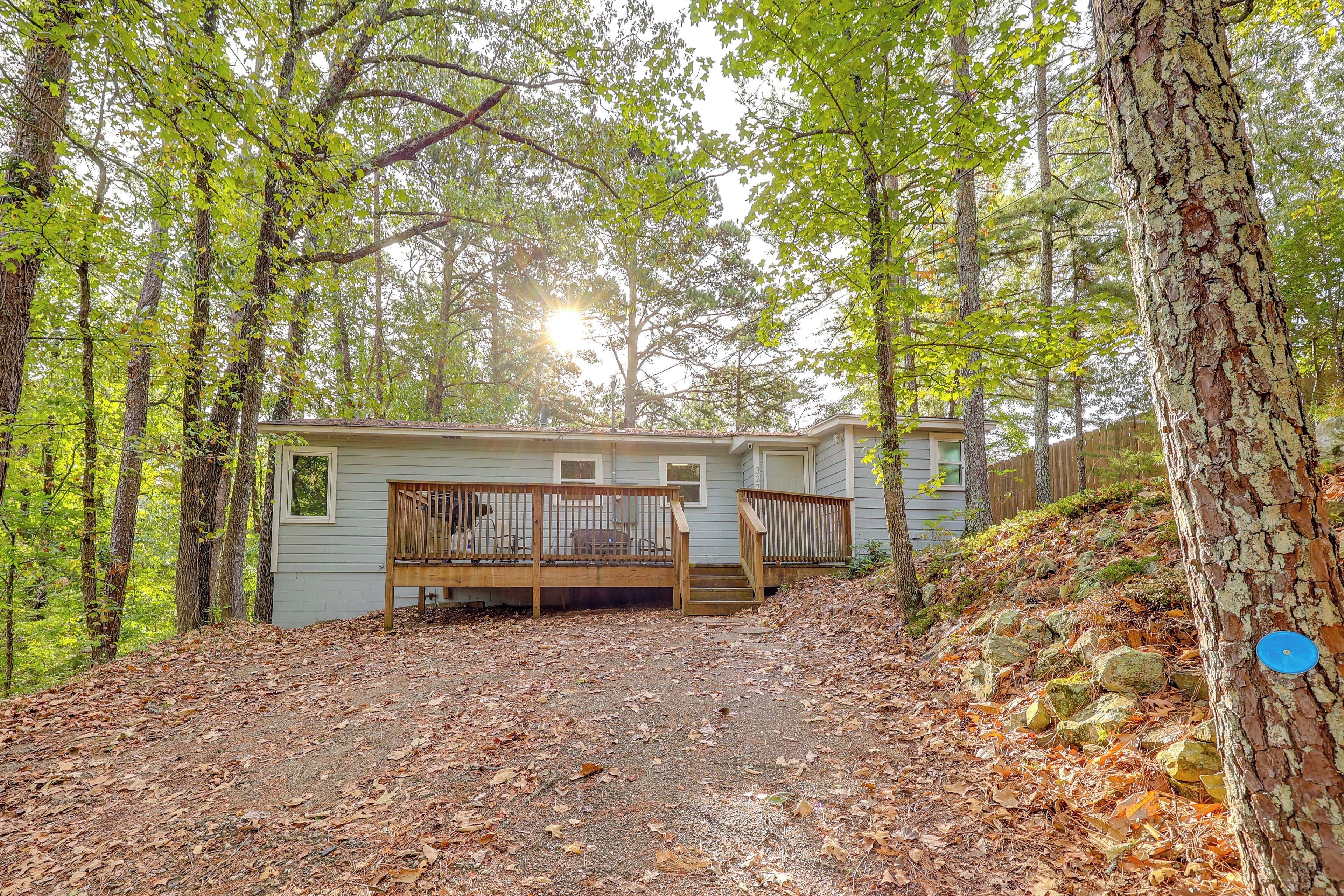 Une cabane dotée d’une terrasse en bois et d’un chemin en pierre menant à l’entrée.