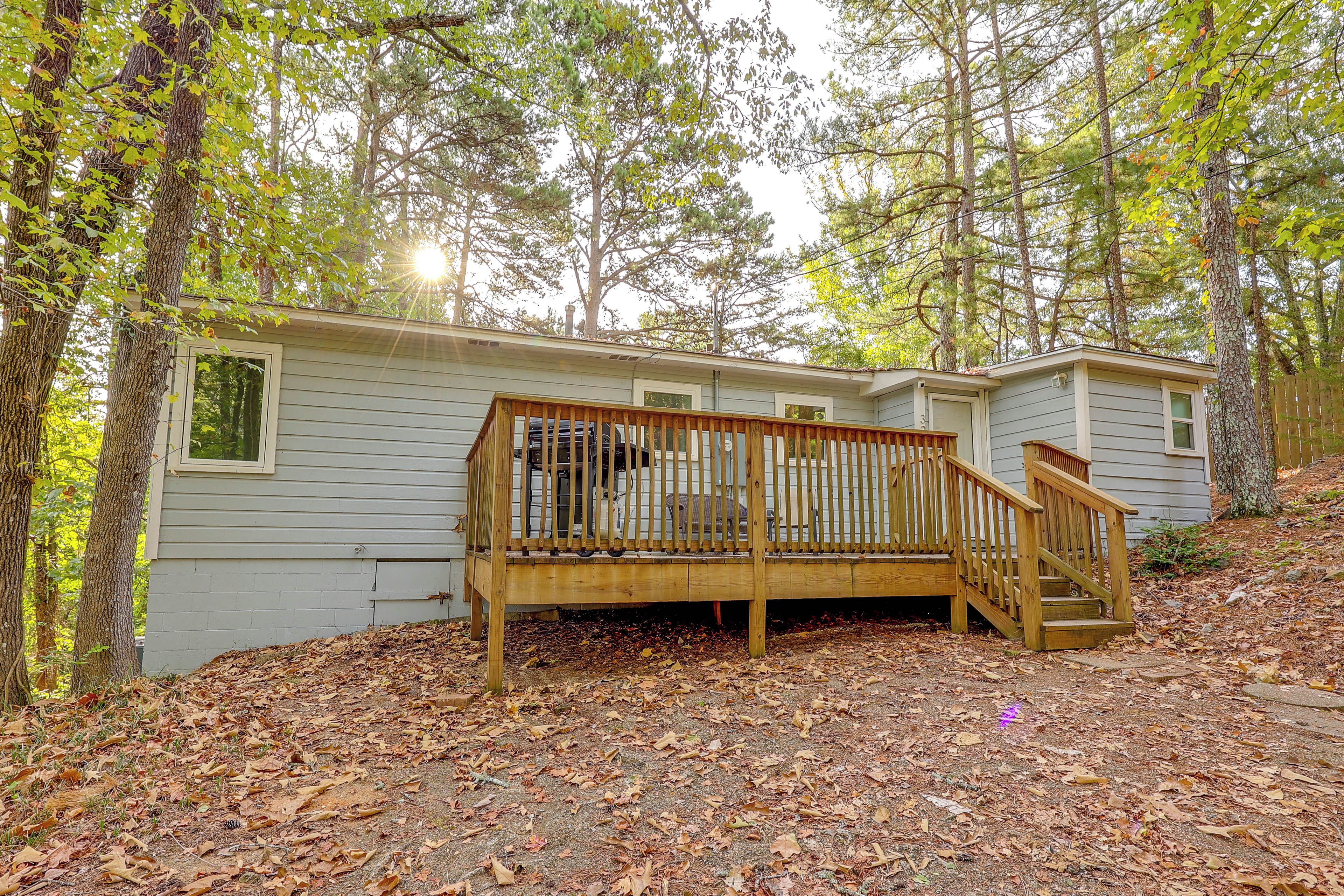 A single-story cabin with a wooden deck and a staircase leading to the entrance.