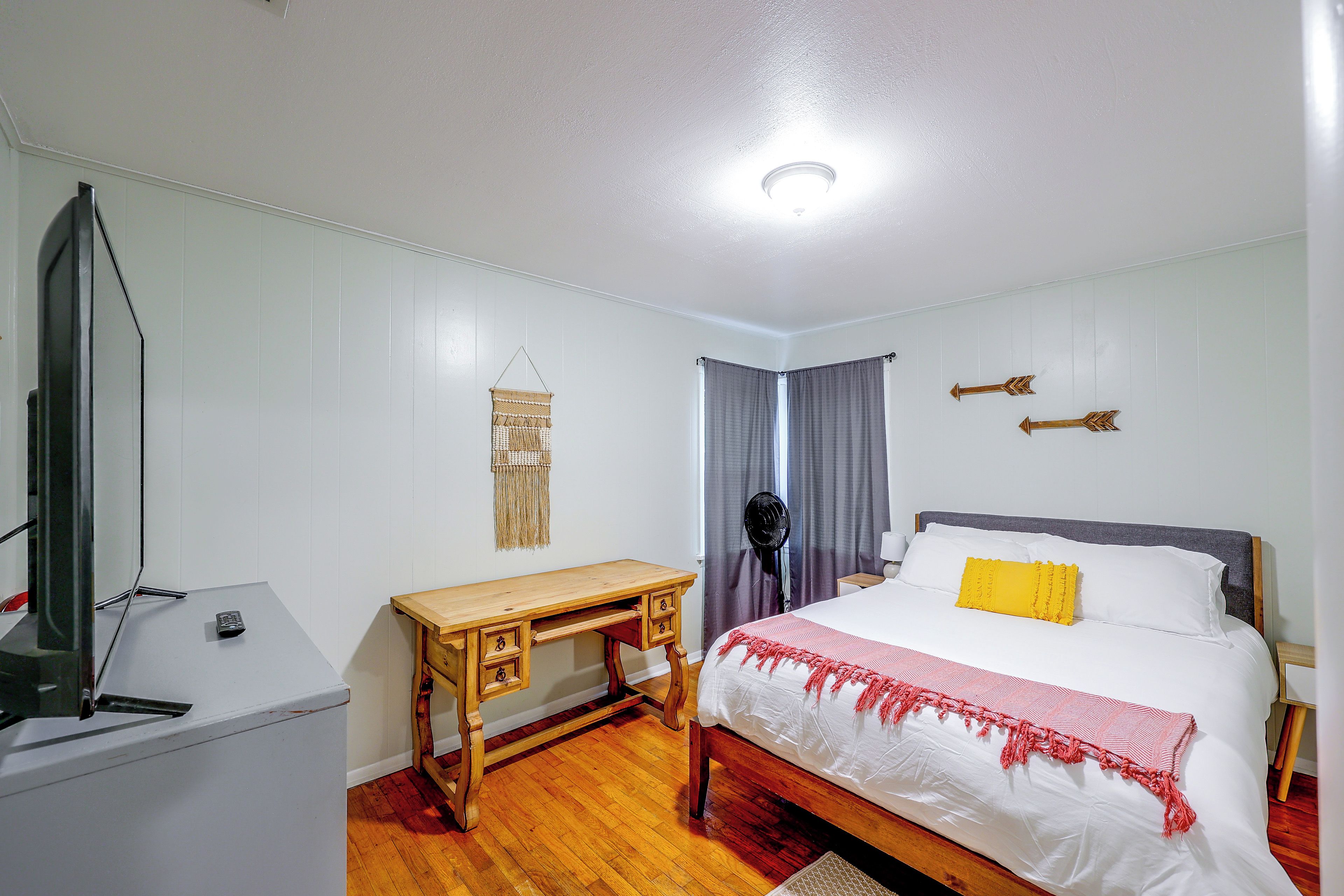 Une chambre à coucher avec un lit, une table de chevet et un bureau.