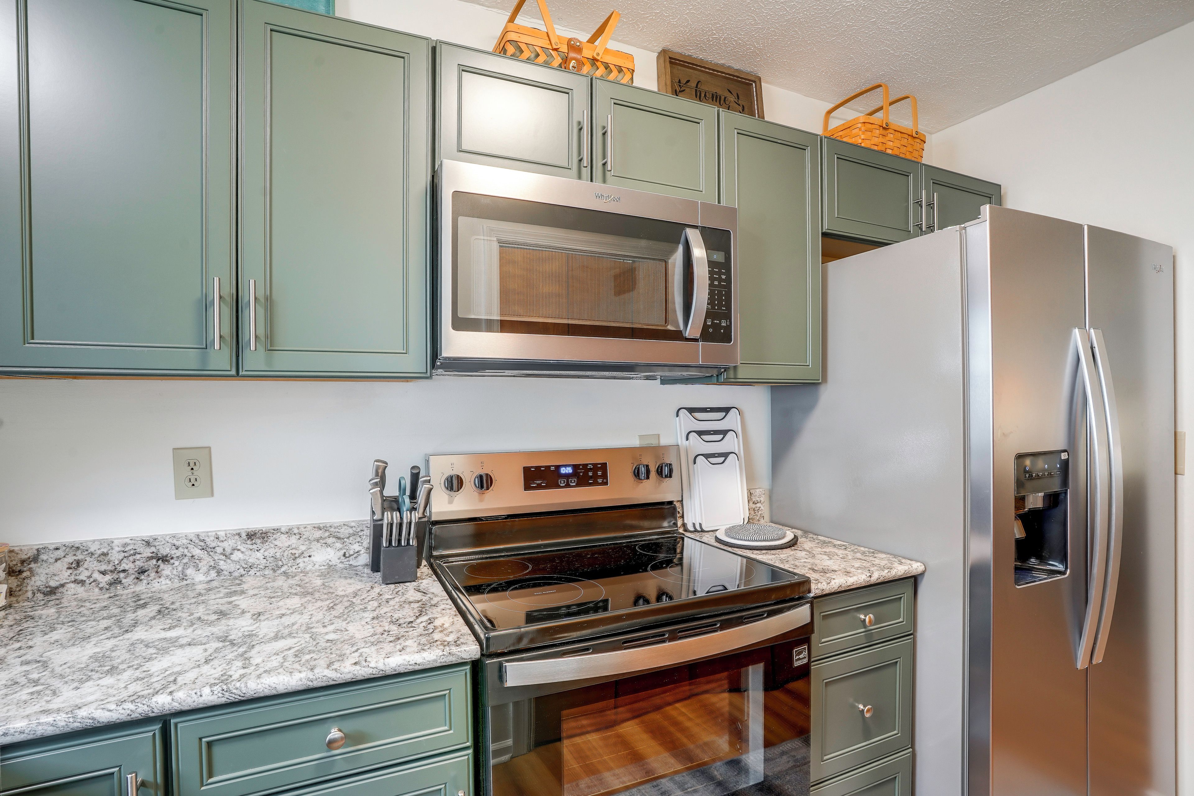 A kitchen with a built-in microwave, oven, and refrigerator.