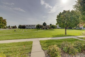 A well-maintained grassy area with a pathway leading to a row of houses. - Shakopee Townhome Near Valleyfair & Mystic Lake (Shakopee)
