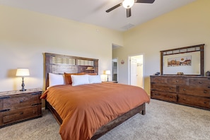 A bedroom with a bed, two nightstands, a dresser, a ceiling fan, and a door leading to another room. - Tucson Extended Stay Overlooking Kitt Peak (Tucson)