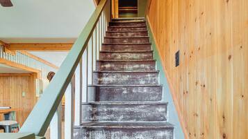 Un escalier en bois avec une rampe verte menant à un palier.
