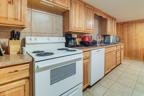 A kitchen with wooden cabinets, a white stove, a dishwasher, and a coffee maker. - Mindenmines Farm Getaway Near Pittsburg (Mindenmines)