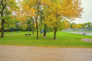 Un parc amb un parc infantil, una panxa de braç i una pista de bàsquet.