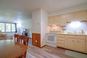 Cocina compacta con estufa, horno y armarios de madera.