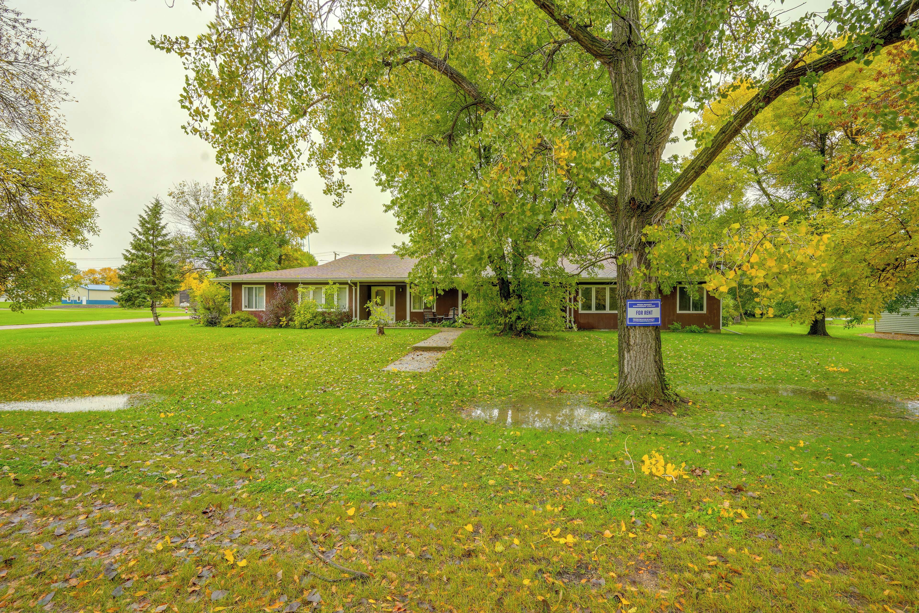 A residential property with a lawn, a house, and a tree.
