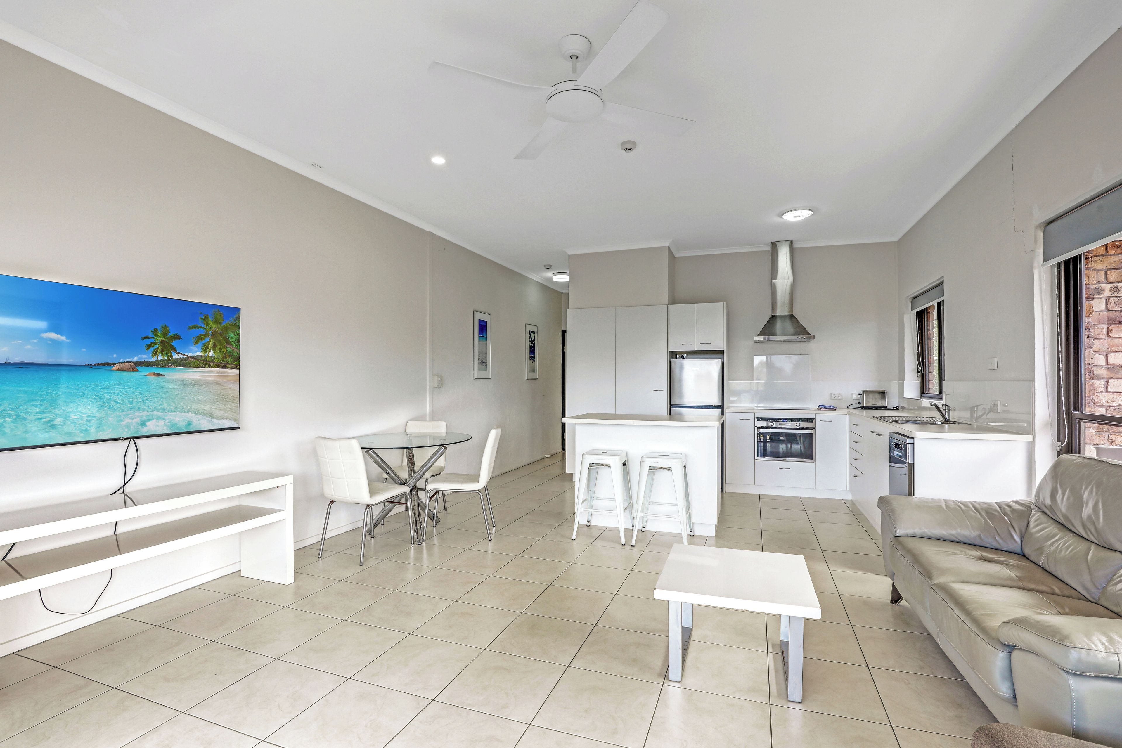 A modern living space with a dining area, kitchen, and seating.