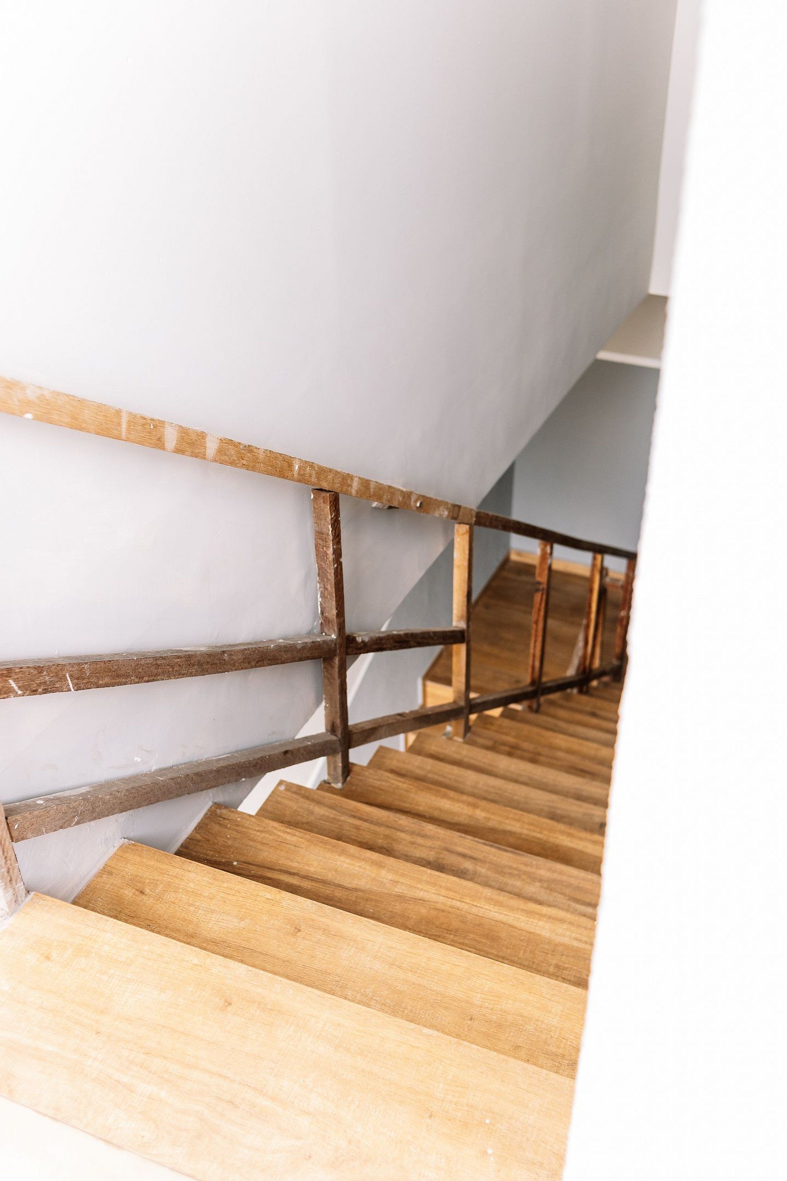 Una escalera de madera con barandilla de metal.