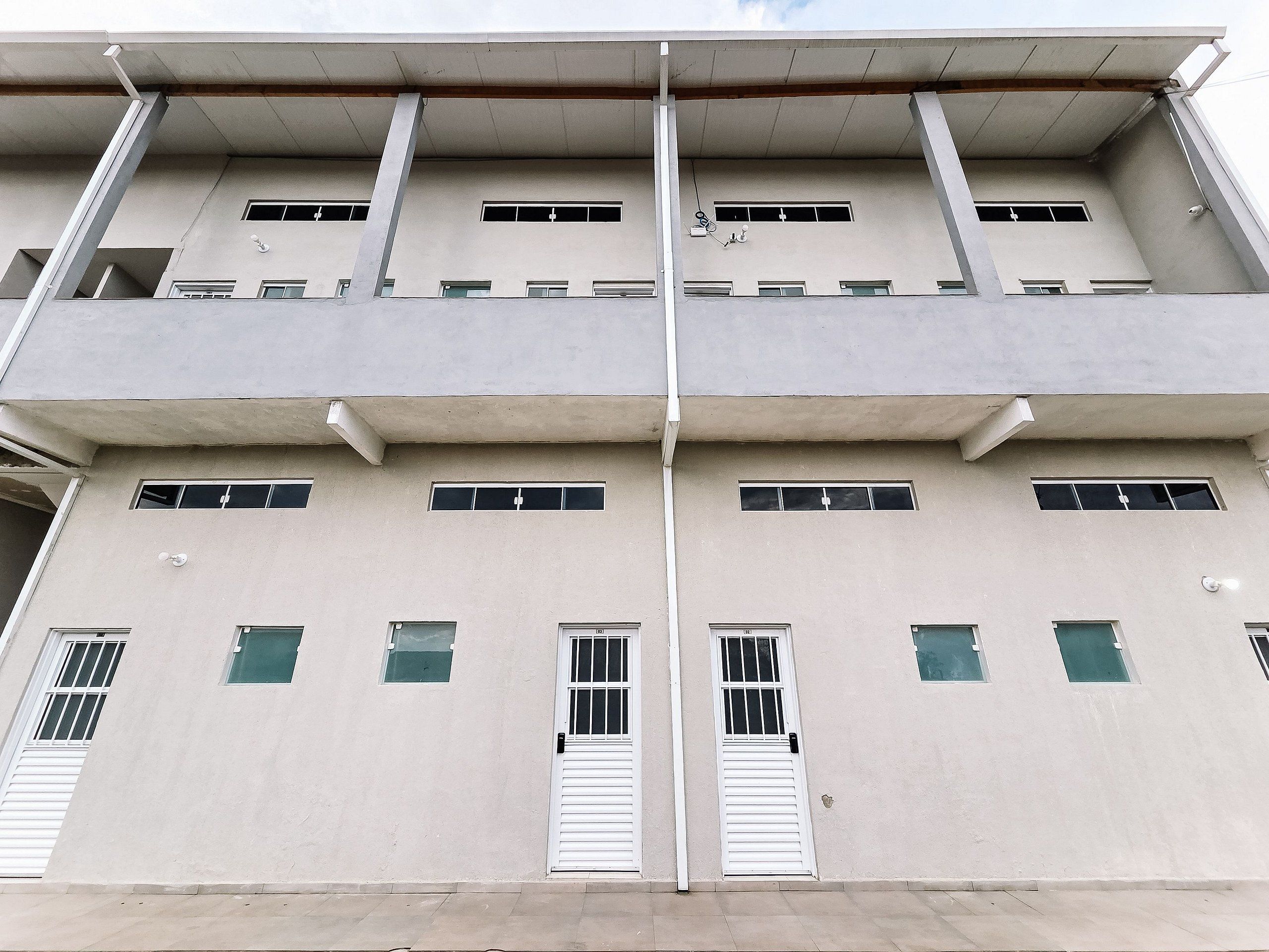 A multi-story building with a flat facade, multiple windows, and a central vertical structural element.