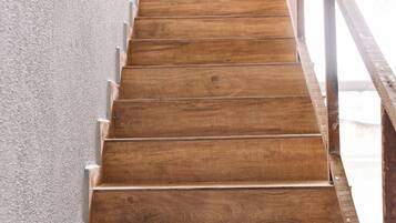 A wooden staircase with a metal railing, leading upwards.