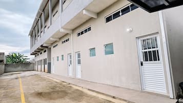 A multi-story building with a flat facade, multiple windows, and a gated entrance.