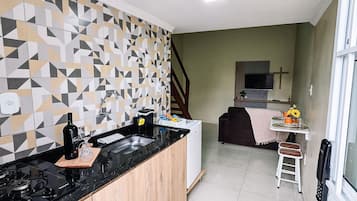 A modern kitchen with a black countertop, wooden cabinets, and a patterned backsplash.