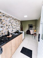 Una cocina moderna con encimera negra, armarios de madera y salpicadero decorado.
